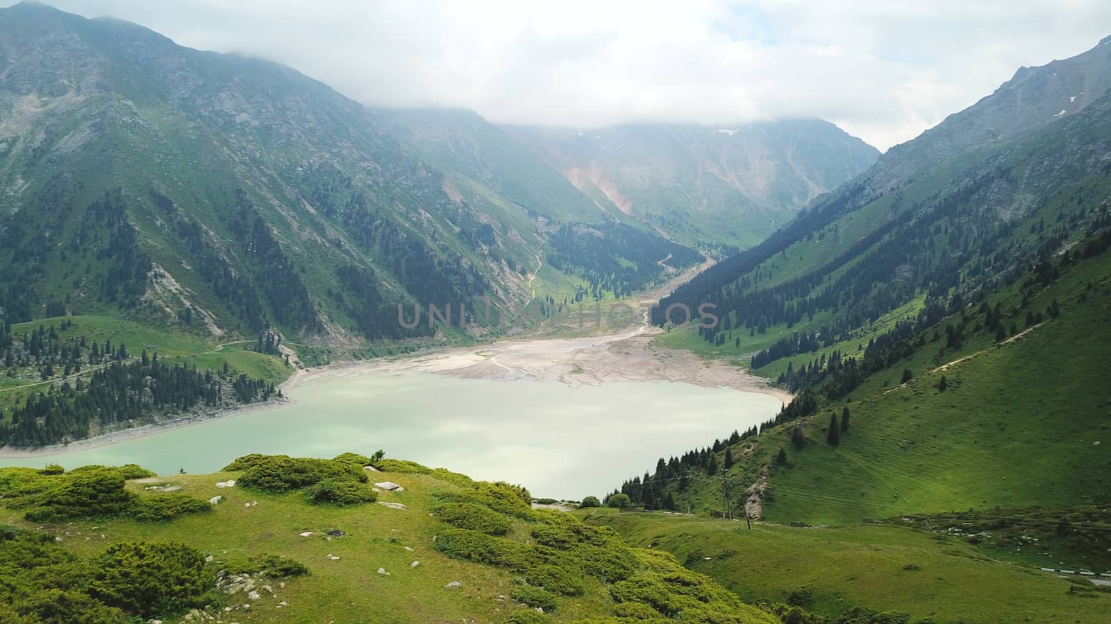 Big Almaty lake in the mountains. Green hill. by Passcal