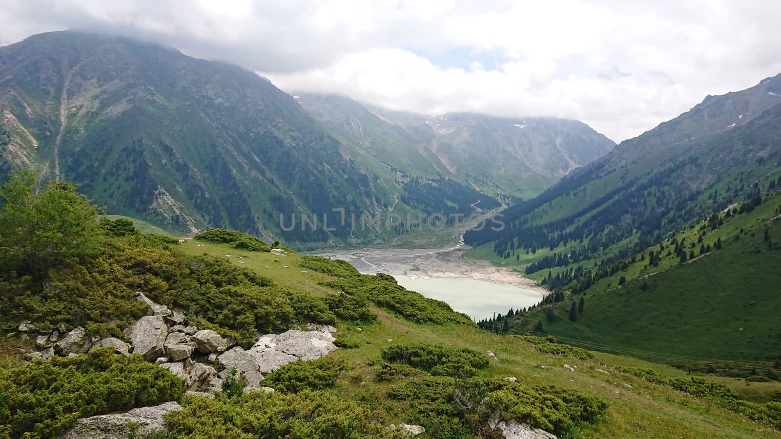 Big Almaty lake in the mountains. Green hill. by Passcal