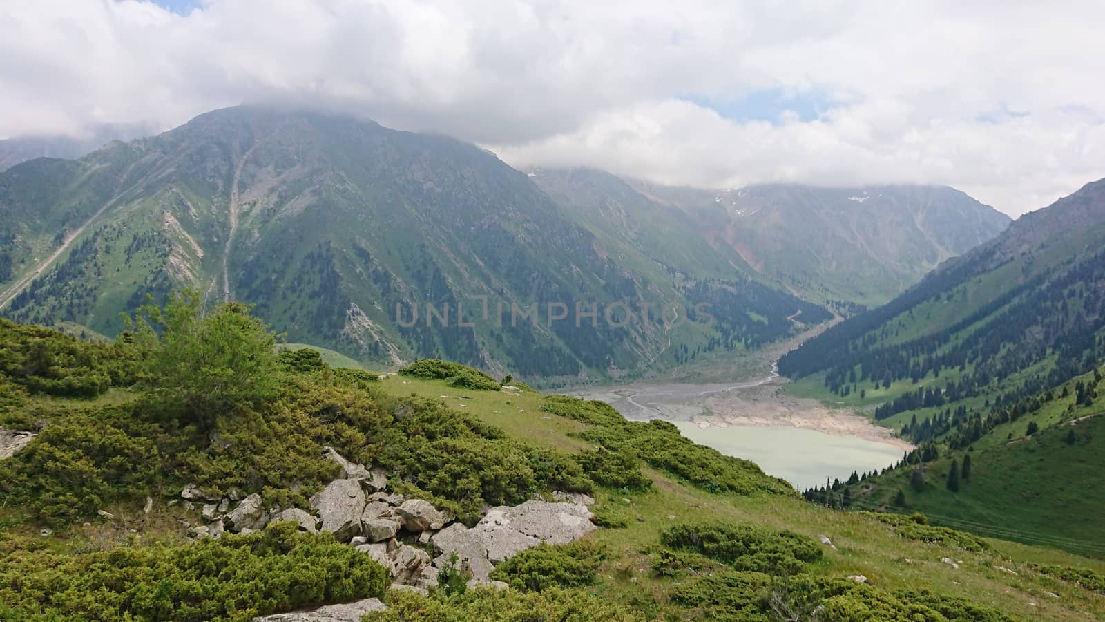 Big Almaty lake in the mountains. Green hill. by Passcal