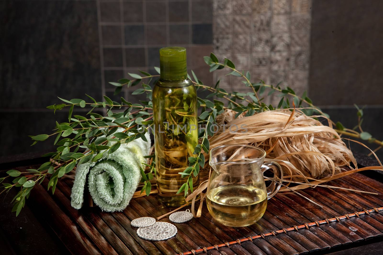 Oil, towels and green leaves on a wooden desk