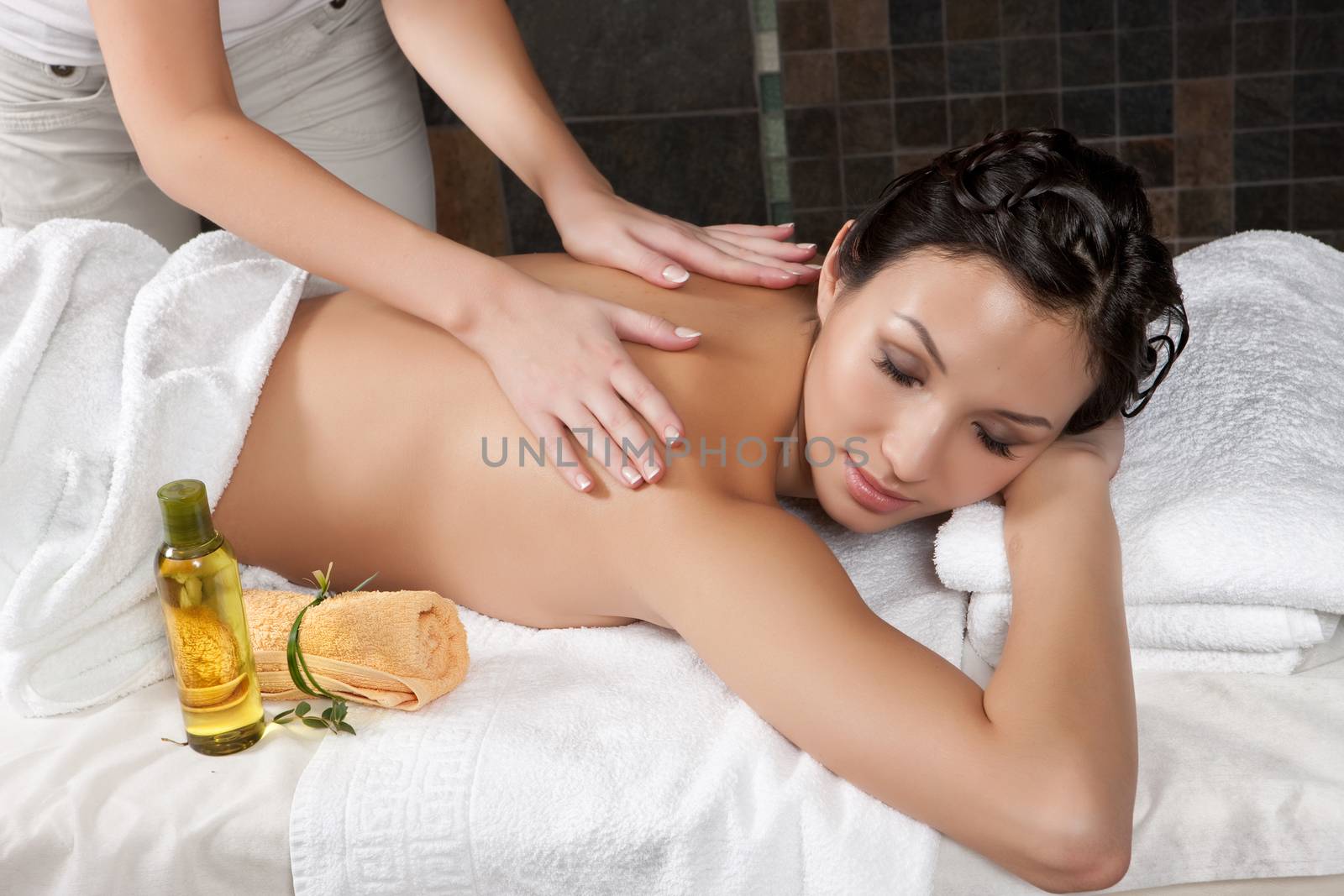 Young attractive woman taking massage and spa procedures