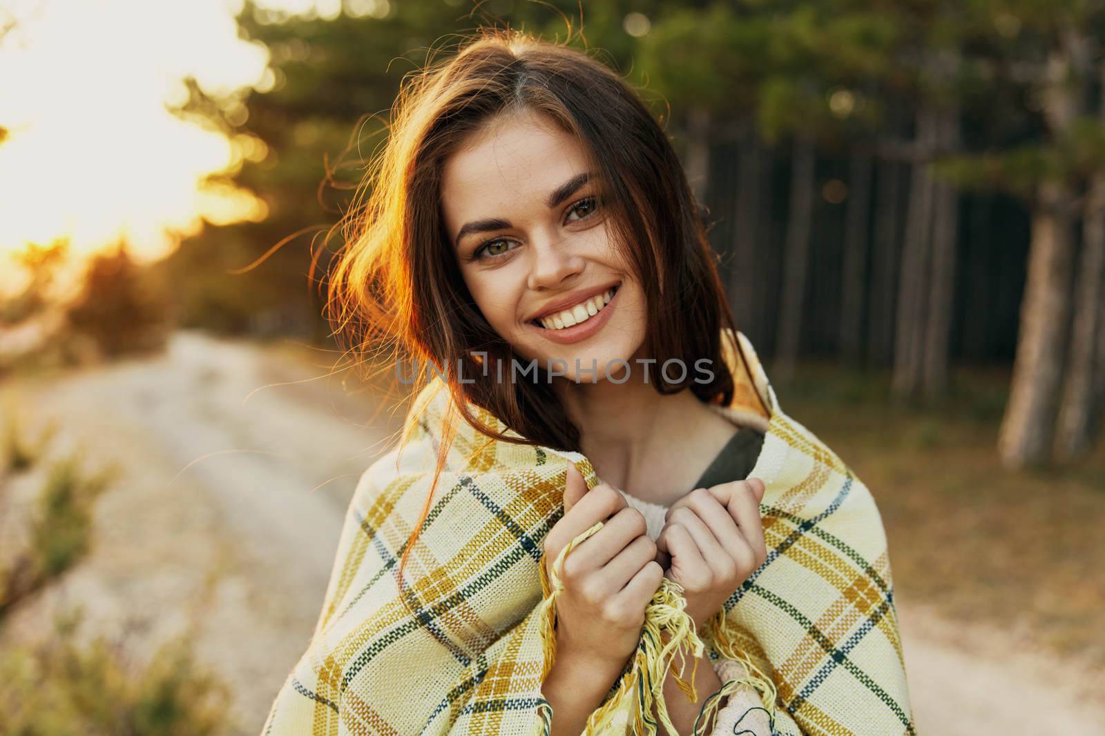smiling woman with a blanket on her shoulders outdoors fresh air morning relaxation. High quality photo