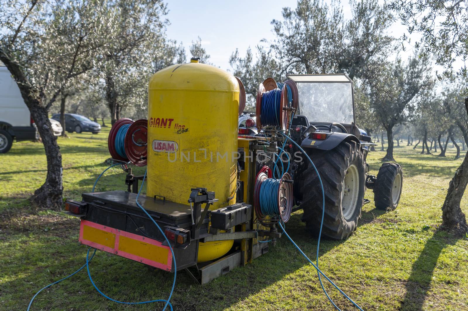 terni,italy november 26 2020:tractor running for olive harvest and compressor attached behind