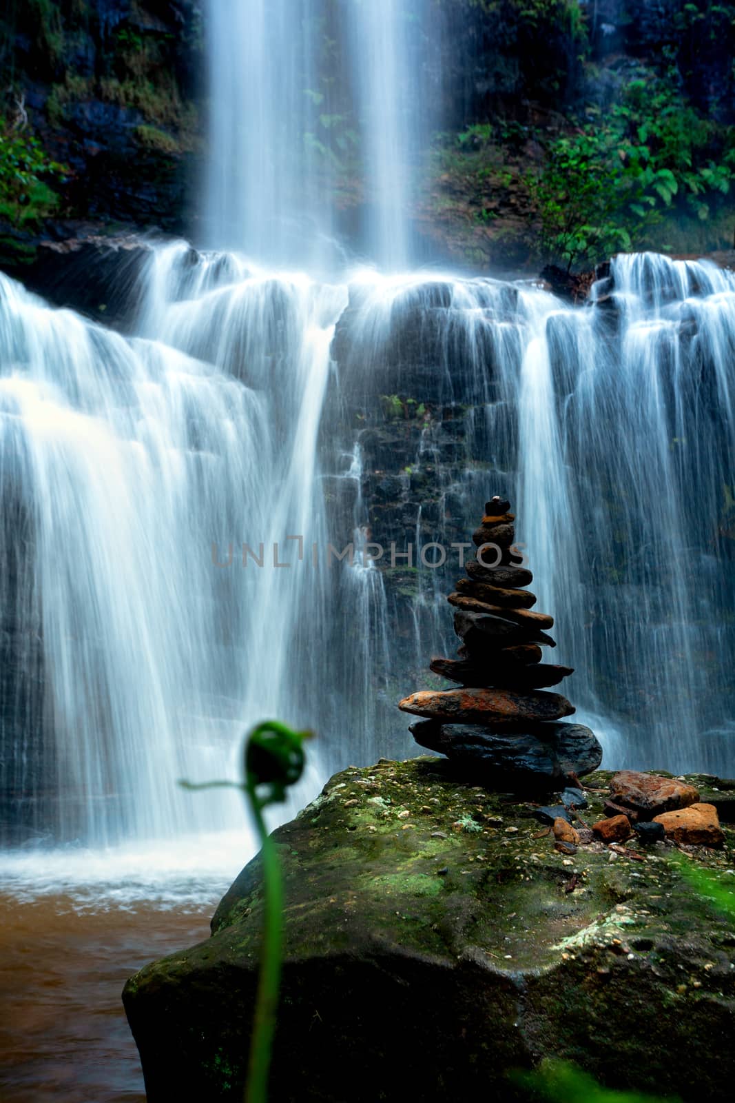 Zen waterfall with lush foliage and balancing stones by lovleah