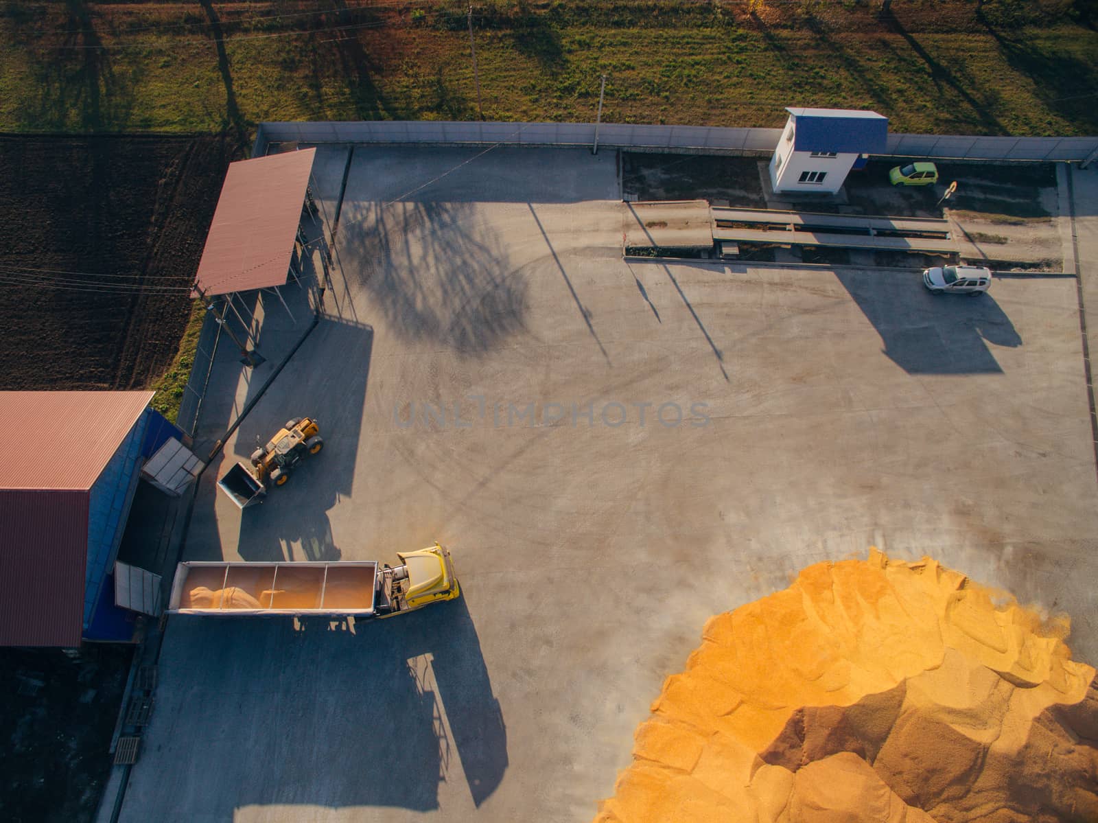 Truck Unloads Corn Grain. Aerial View Over The Grain Warehouse.