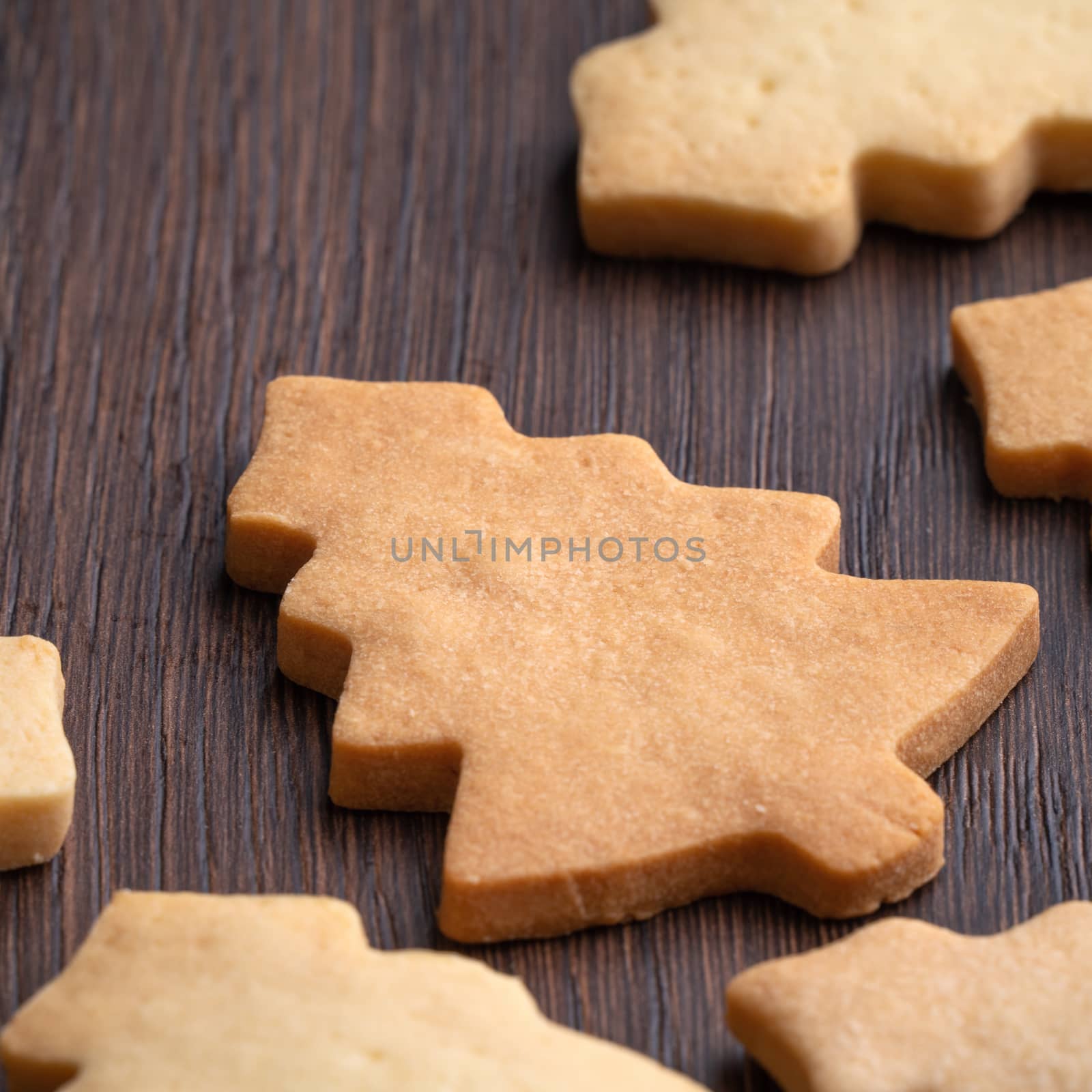 Top view of decorated Christmas tree gingerbread cookie on wooden table background with copy space, concept of holiday celebration.