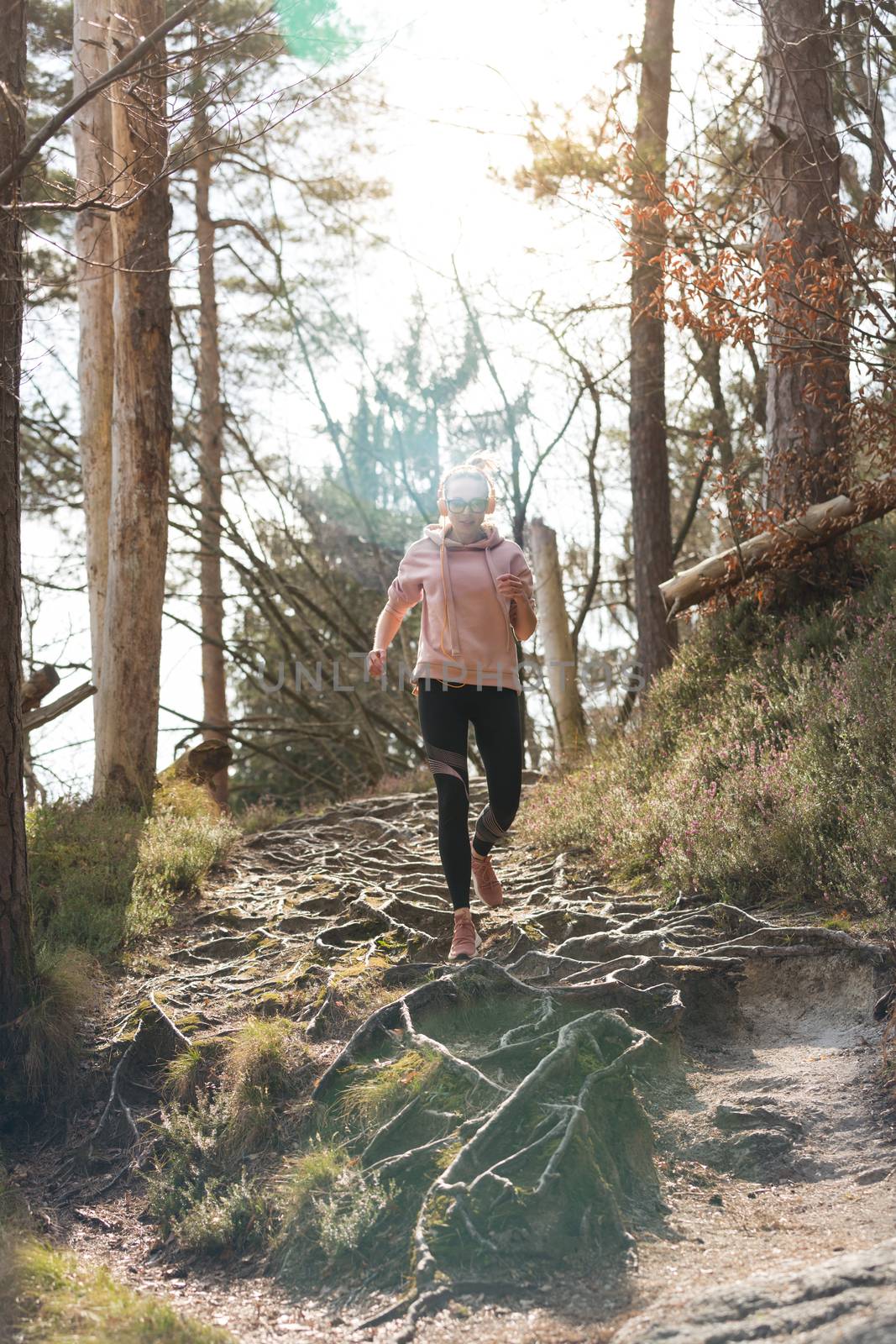 Active sporty woman running in autumn fall forest. Female runner training outdoor. Healthy lifestyle image of young caucasian woman jogging outside. by kasto