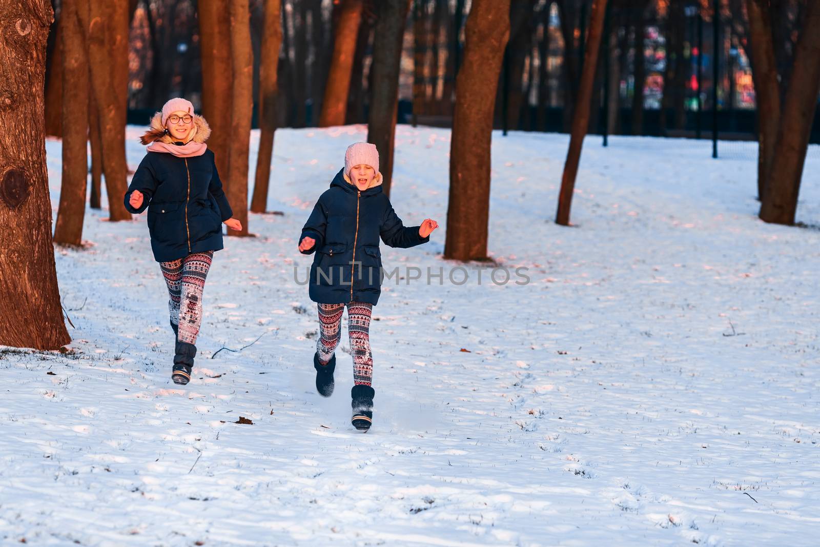 Beautiful teenage girls having fun in the forest in winter