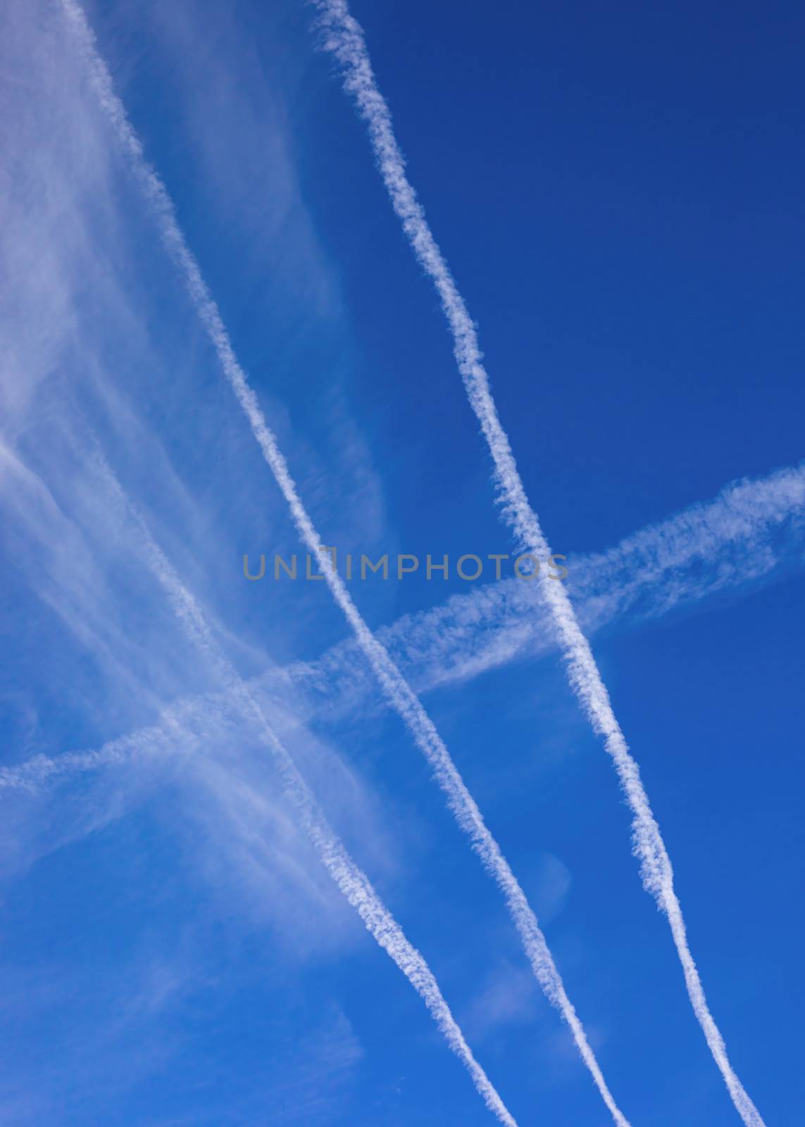 Jet contrails criss-cross on a bright blue fall morning.