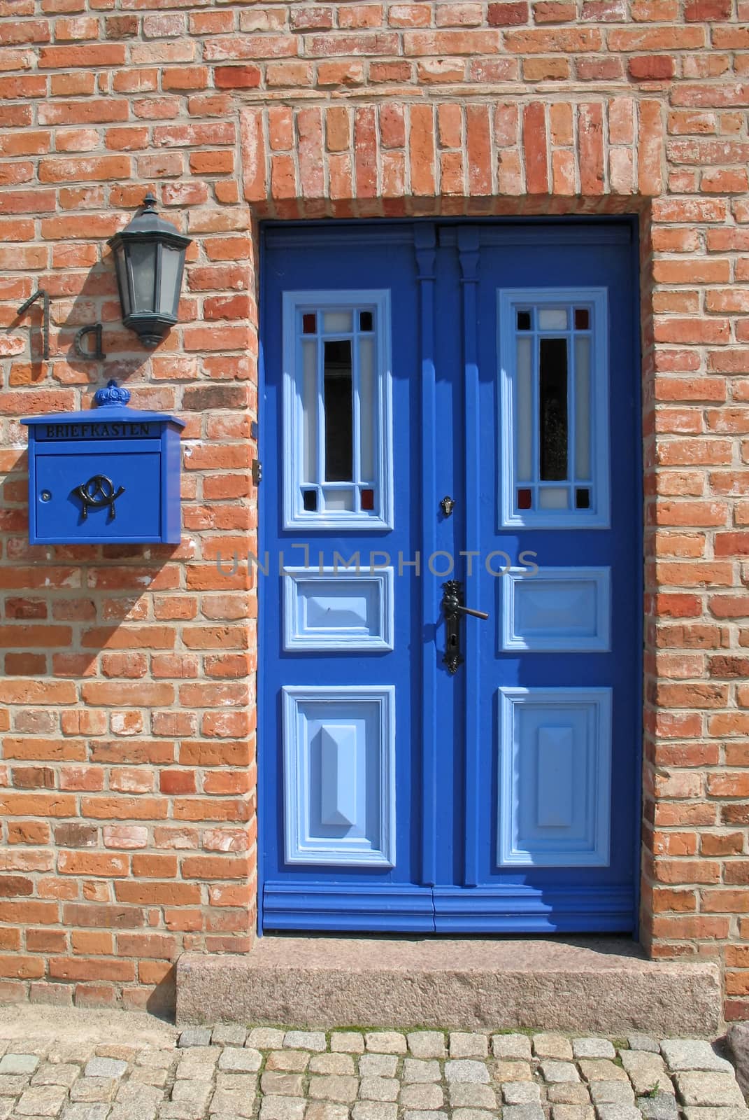 Light blue and dark blue painted wooden door with stained glass windows.
