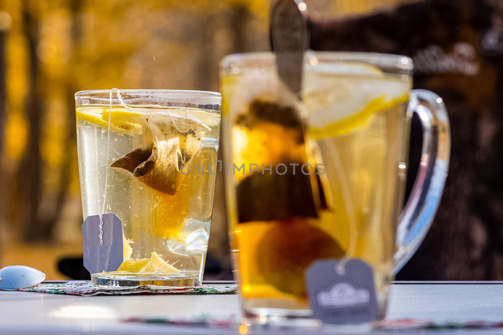 Transparent mug with tea. Brewing tea in a bag. Tea with lemon.