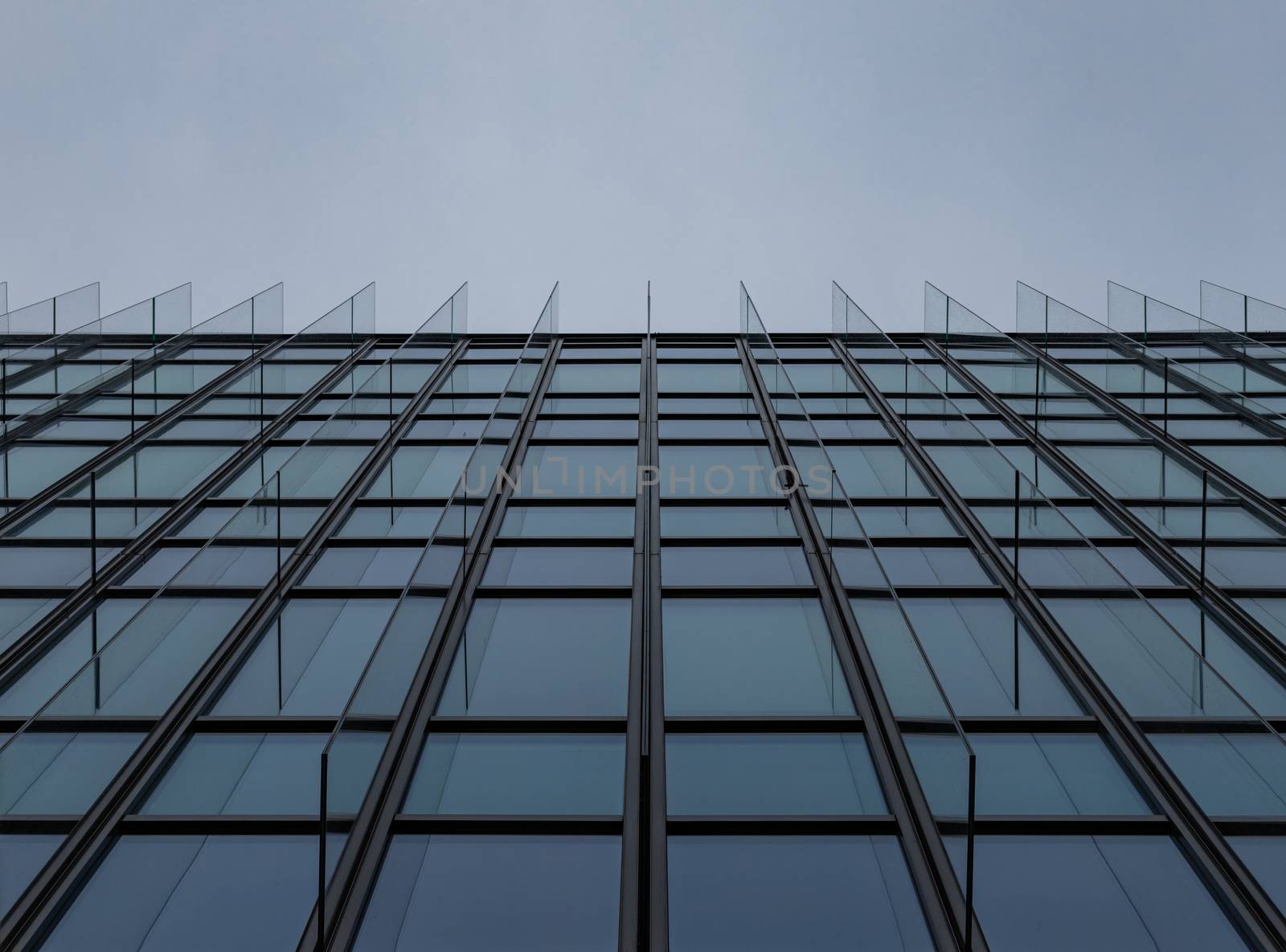 Upward view to wall of high glassy corporate building