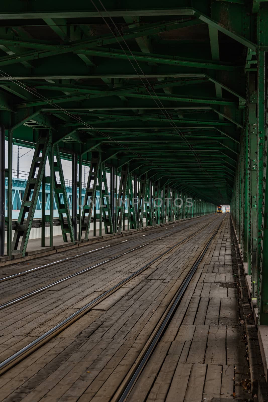 Long wooden and metal bridge with tram rails and green construction
