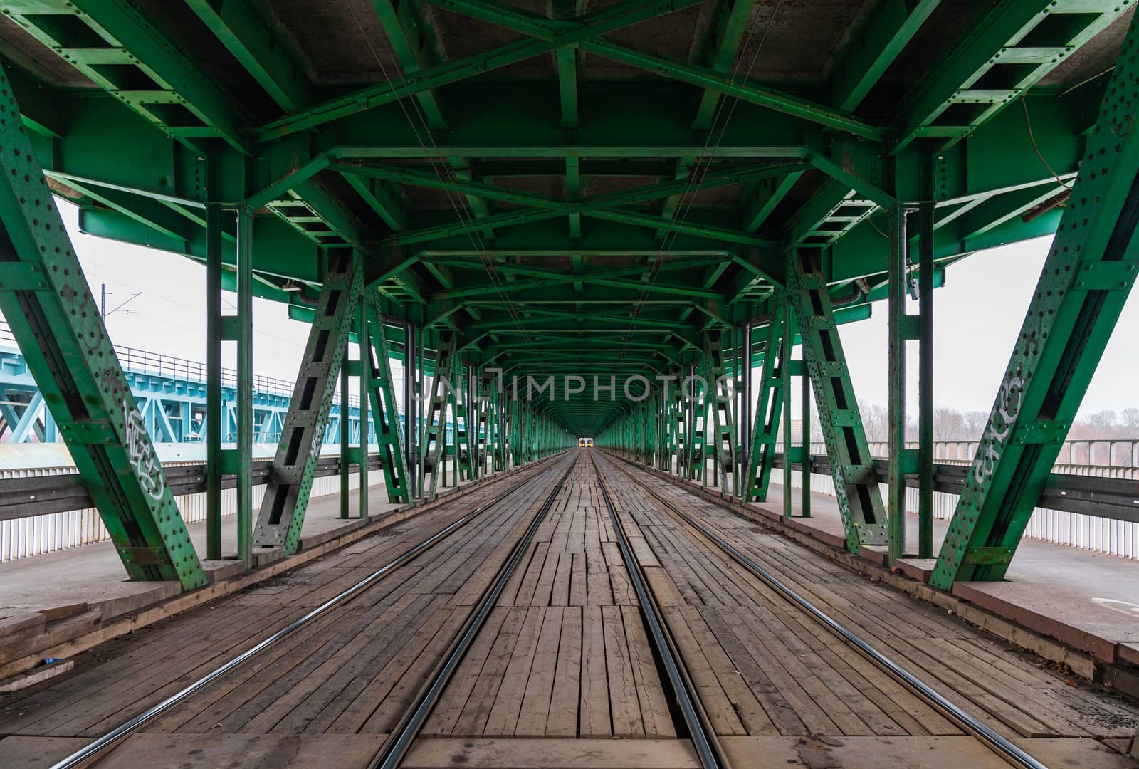 Long wooden and metal bridge with tram rails and green roof by Wierzchu