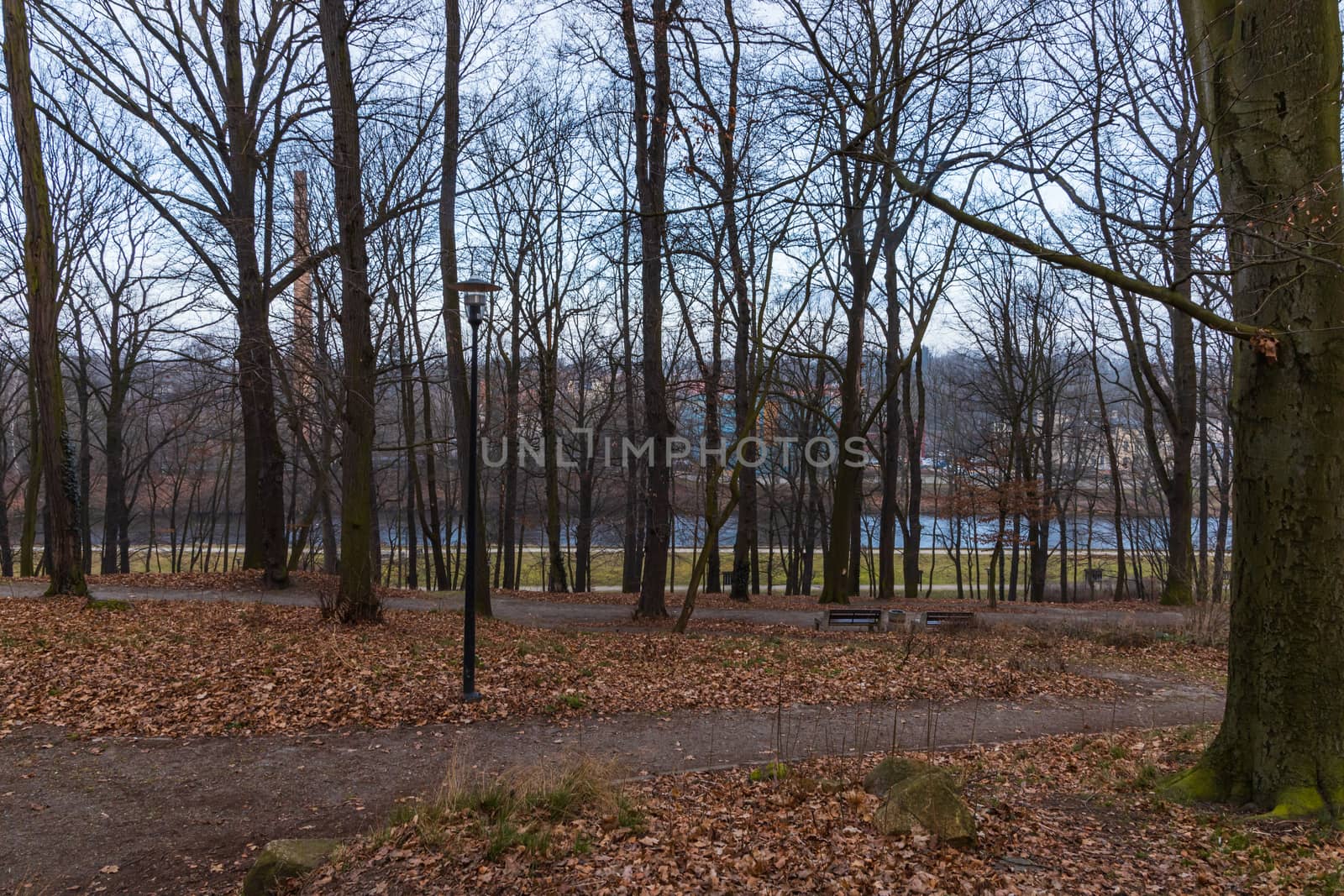 Small river behind park with lanterns and benches around by Wierzchu