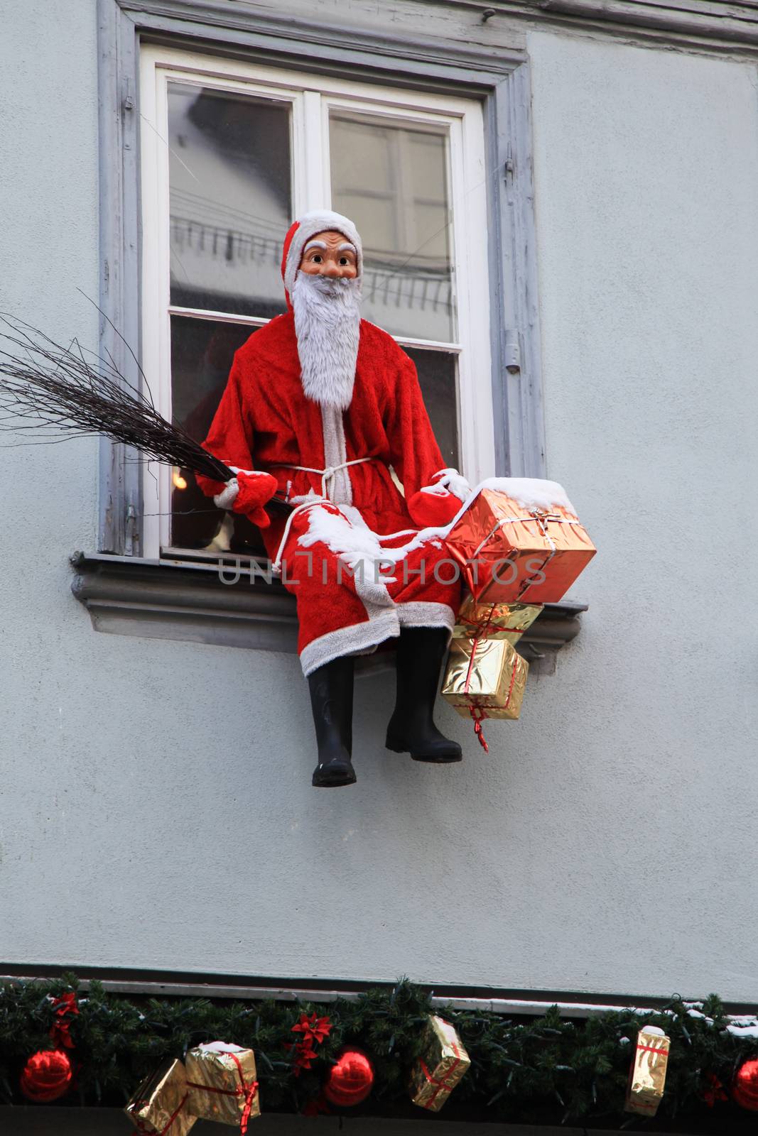 Artificial Santa Claus with gift packages on window sill