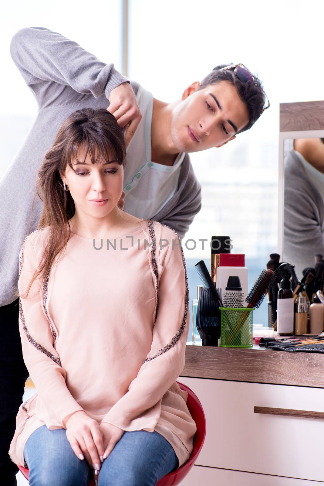 Man stylist working with woman in beauty salon