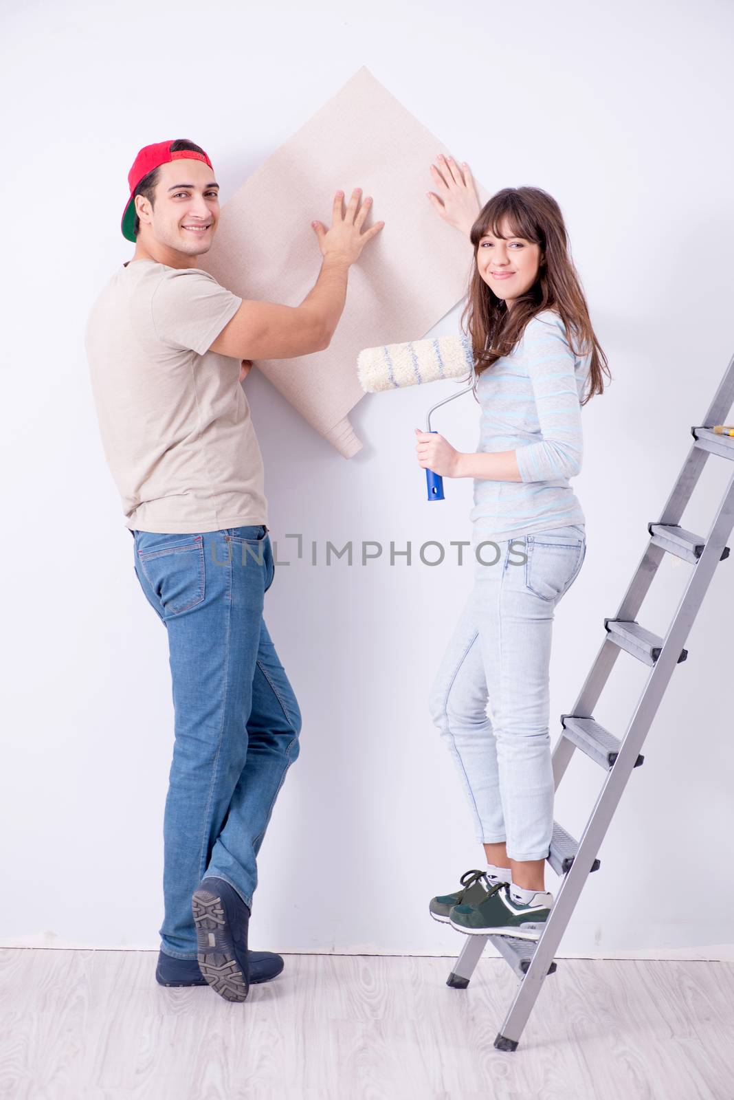 Young family doing renovation at home with new wallpaper by Elnur