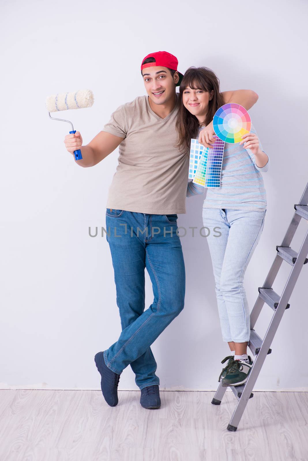 Young family doing renovation at home  - painting walls by Elnur