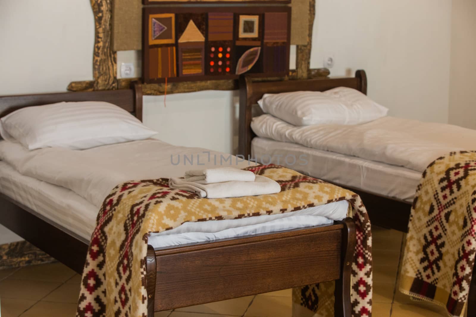 Wooden Bed of a Modern Hotel Room. Exquisite Interior in a Cozy Place. by TrEKone