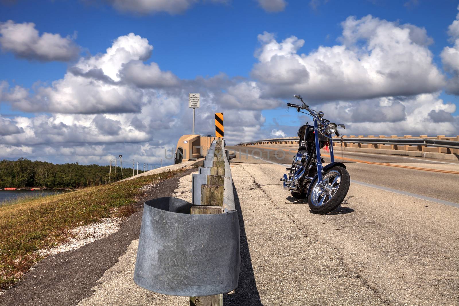 Bonita Beach, Florida, USA – November 16, 2020: Motorcycle along the side of a highway bridge of Bonita Beach causeway over Estero Bay in Bonita Springs, Florida.