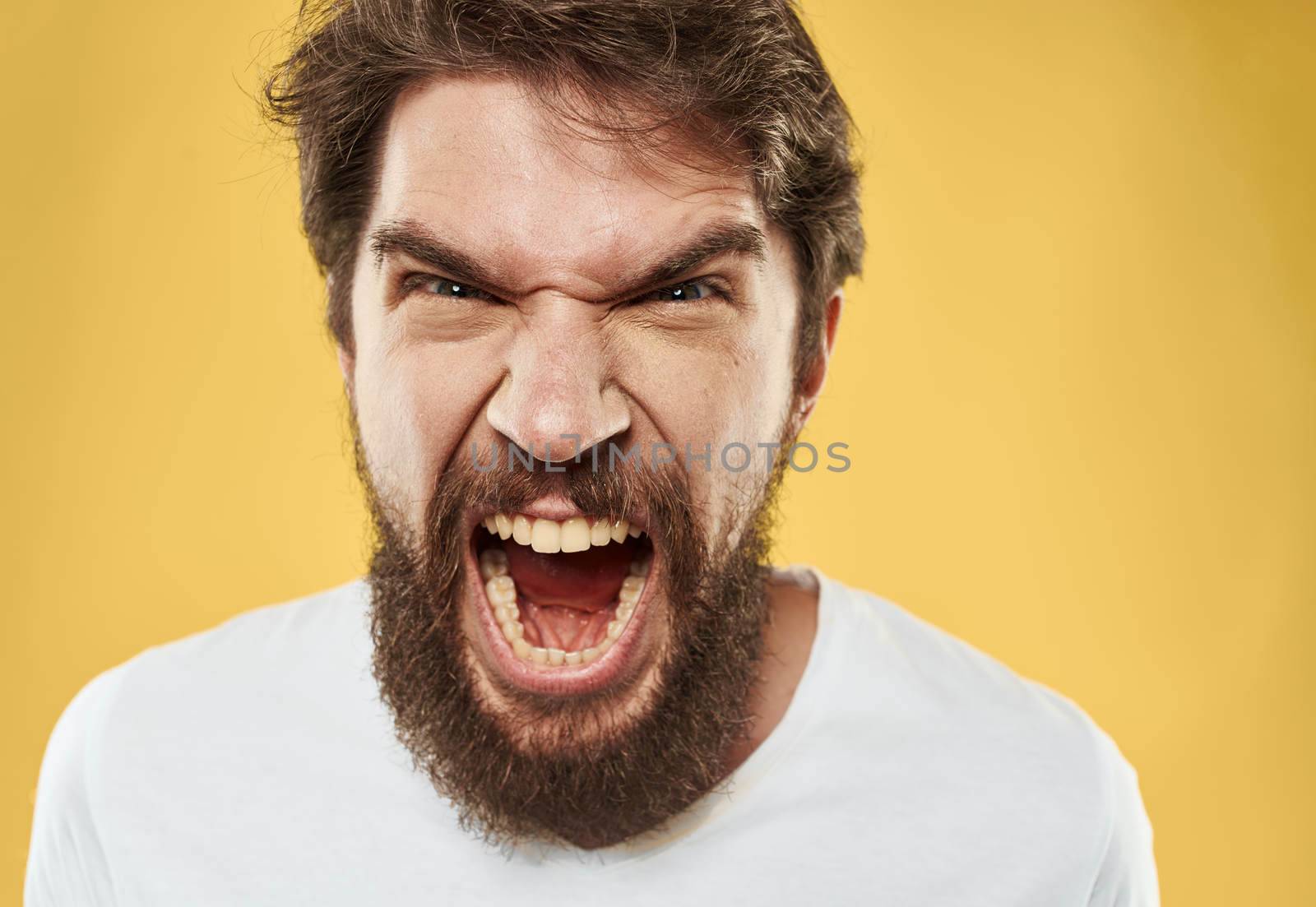irritable young man with beard on yellow background cropped view. High quality photo