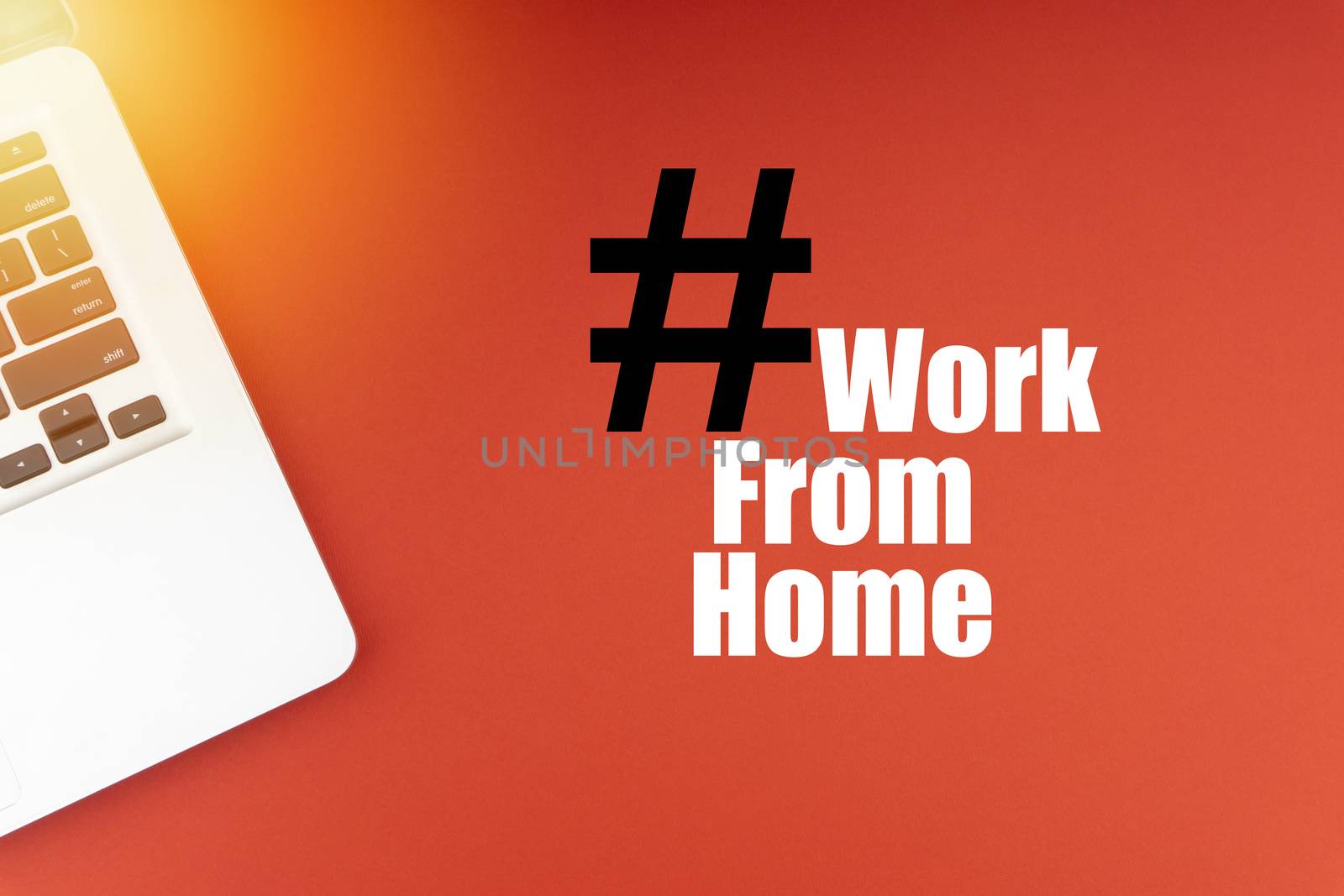 WORK FROM HOME text with laptop on red background. Business and Copy Space Concept