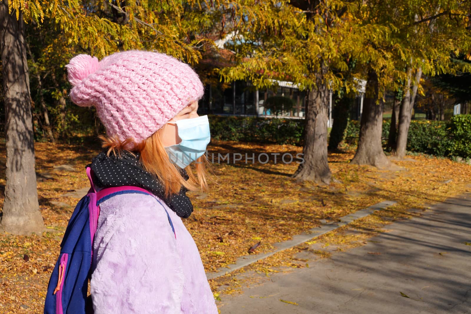 portrait of a teenage girl in a medical mask in an autumn park.