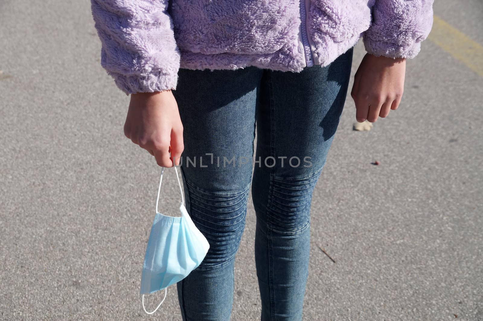 girl holding a medical mask in her hand close up