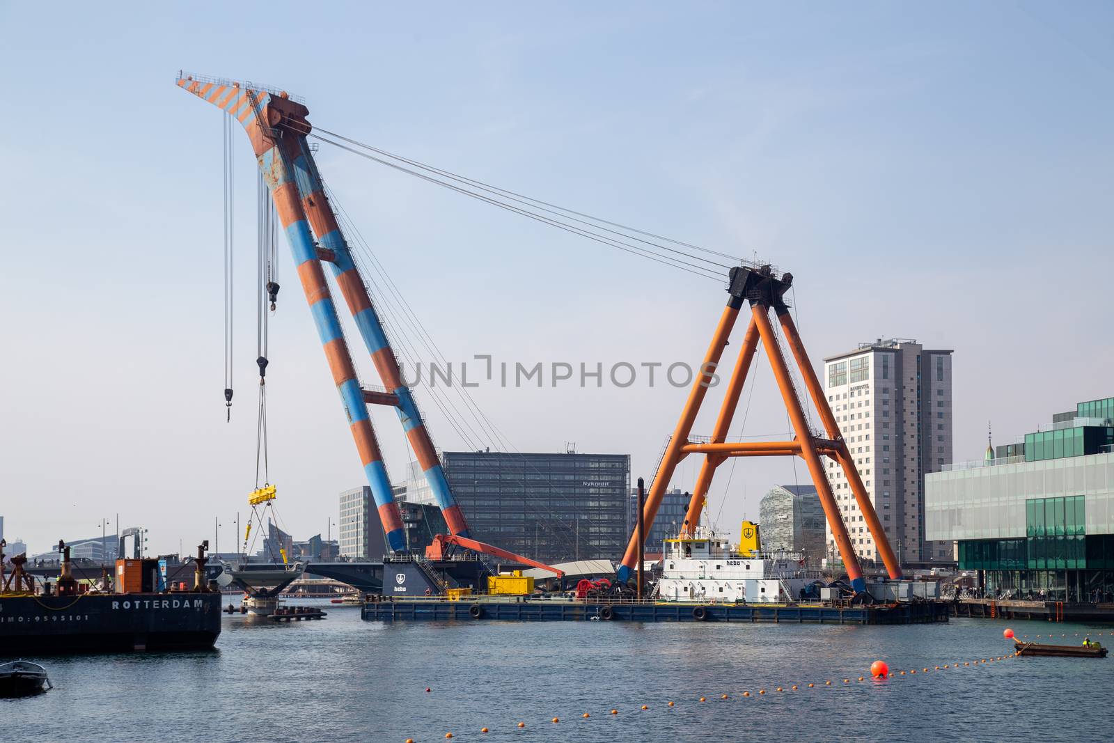 Copenhagen, Denmark - April 4, 2019: The huge Floating Crane Hebo Lift 9 installing parts for a new cycling bridge over the harbour.