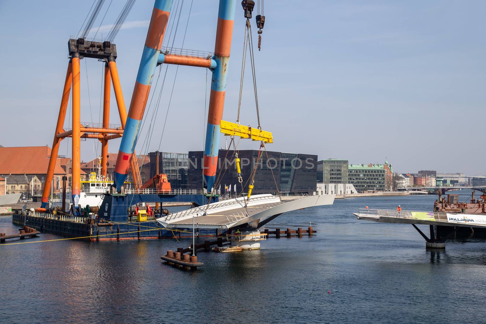 Copenhagen, Denmark - April 4, 2019: The huge Floating Crane Hebo Lift 9 installing parts for a new cycling bridge over the harbour.