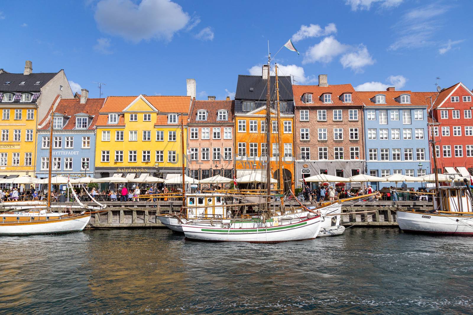 Copenhagen, Denmark - August 21, 2019: Famous Nyhavn district in the city centre with colorful houses.