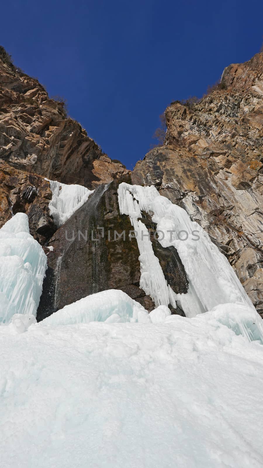 Frozen waterfall among the rocks. by Passcal