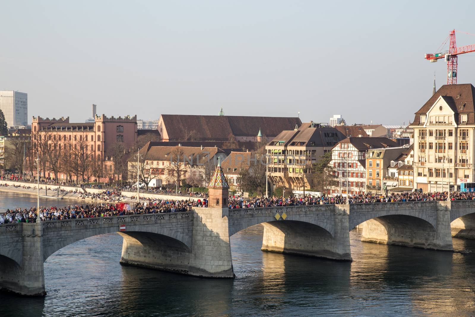 Basel, Switzerland - March 10, 2014: The bridge Mittlere Brucke filled with ddressed up people at the tradtional carnival parade