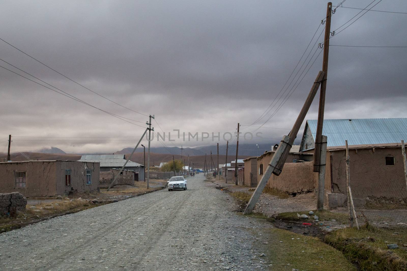 Sary-Mogul, Kyrgyzstan - October 7, 2014: Gravel road and houses in the village Sary-Mogul in South Kyrgyzstan.