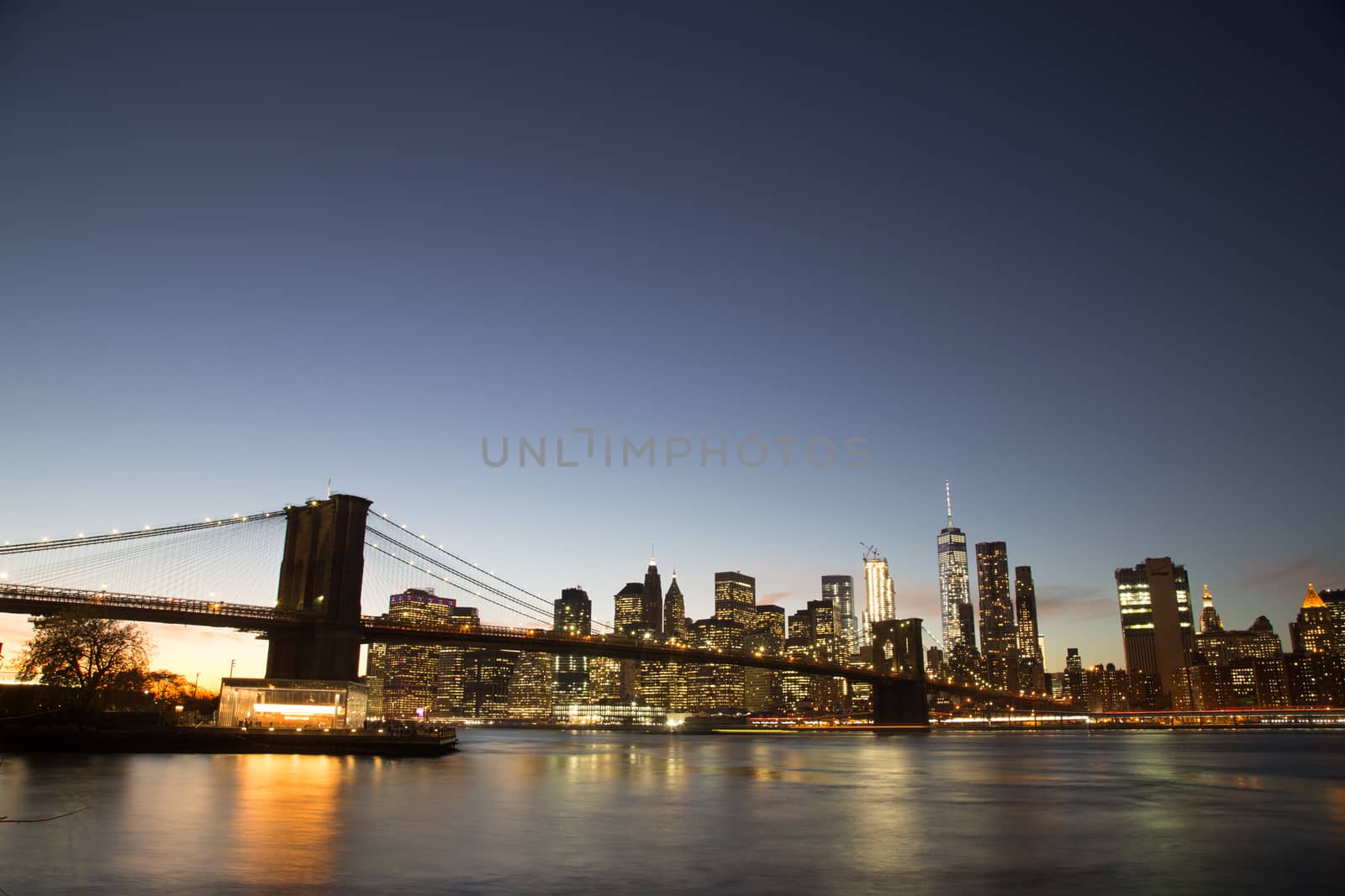 New York, United States of America - November 18, 2016: Skyline of Lower Manhattan with Brooklyn Bridge at sunset.