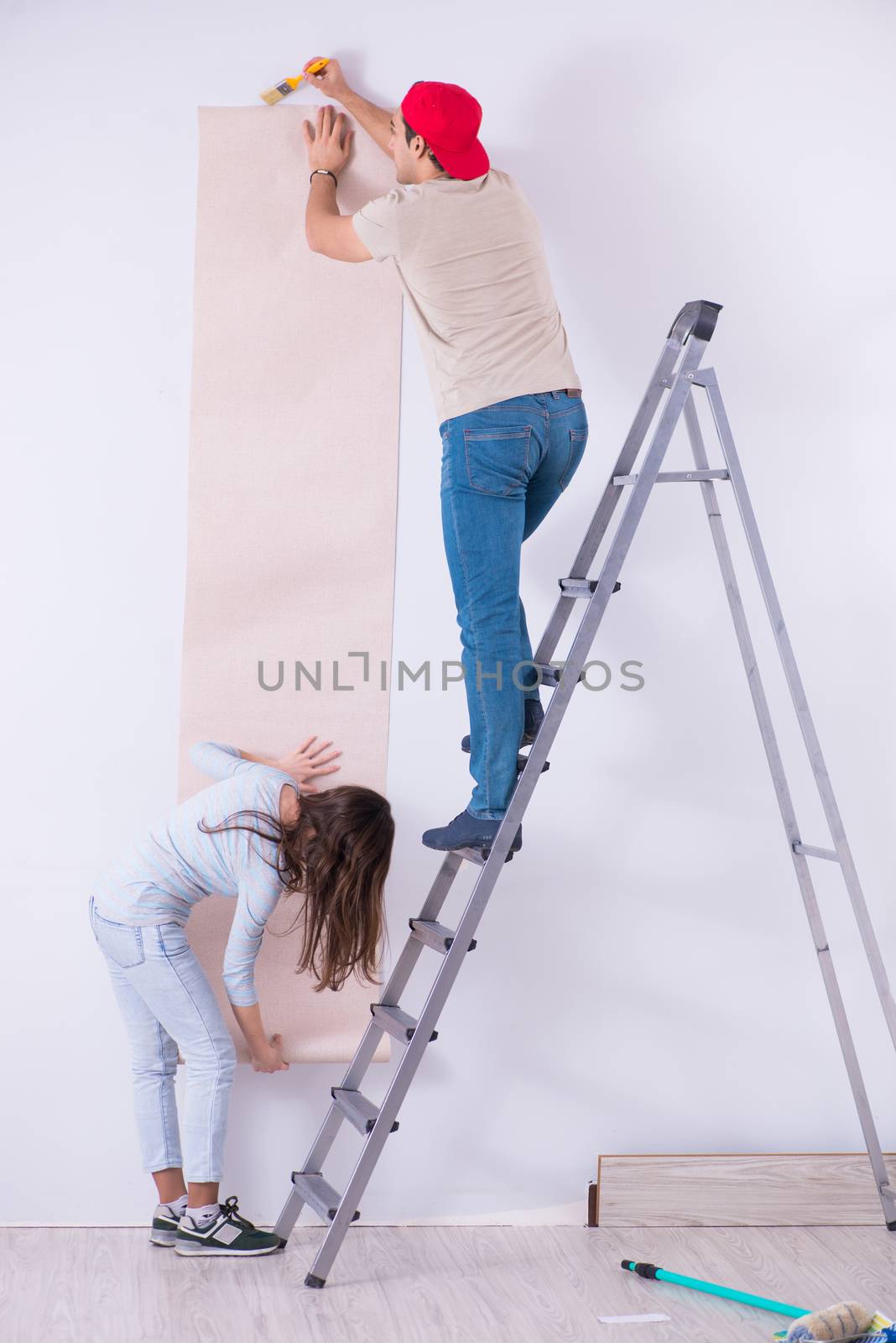 Young family doing renovation at home with new wallpaper by Elnur