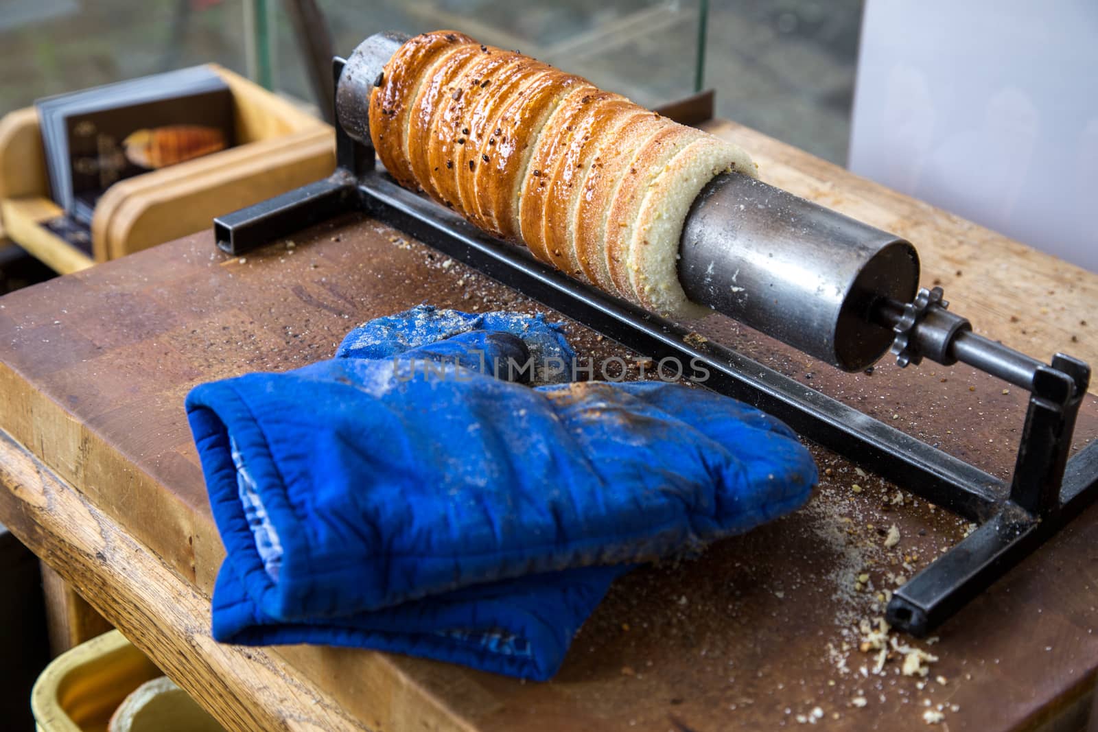 Prague, Czech Republic - March 18, 2017: Famous Czech pastry Trdelnik being baked in a street bakery. Trdelnik, also called Trdlo is a sugary sweet pastry.