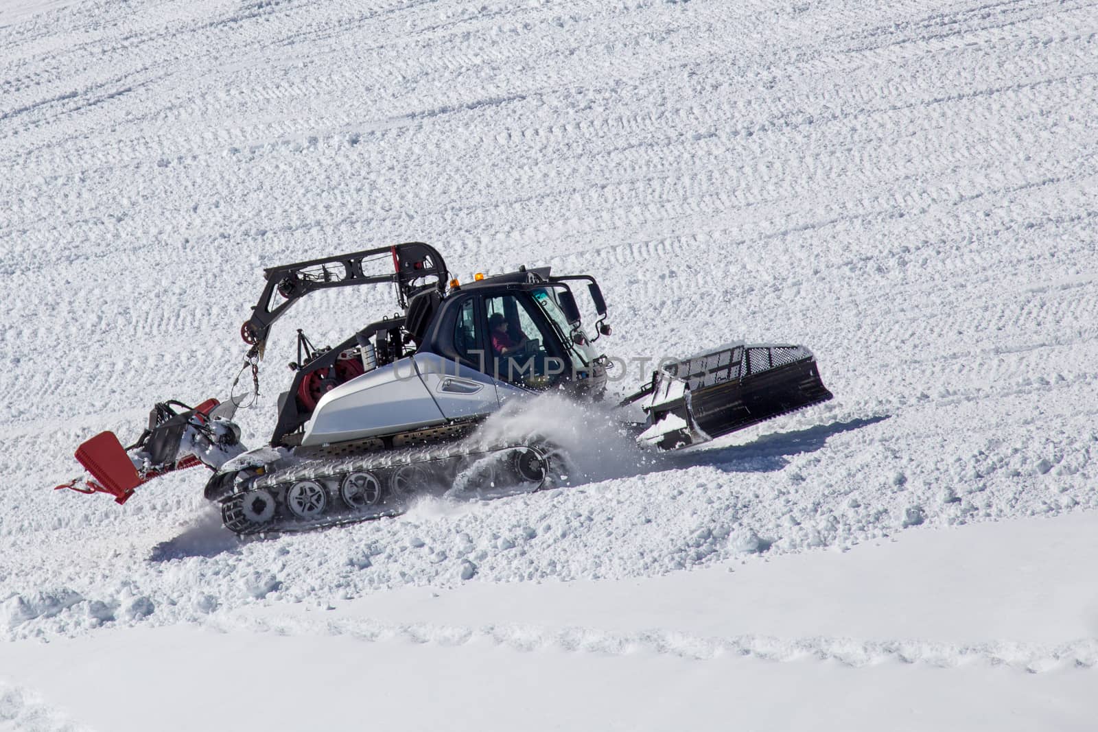 Zermatt, Switzerland - April 13, 2017: A snow groomer working on a skiing slope