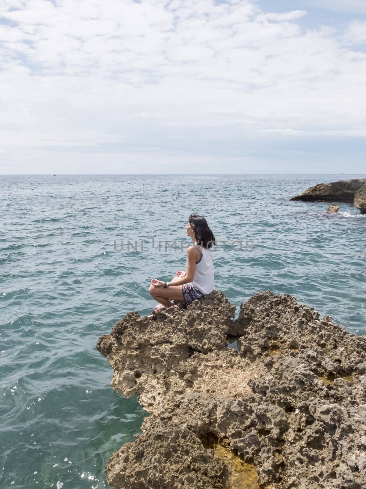 Beautiful woman practicing yoga on the beach at sunrise by raferto1973