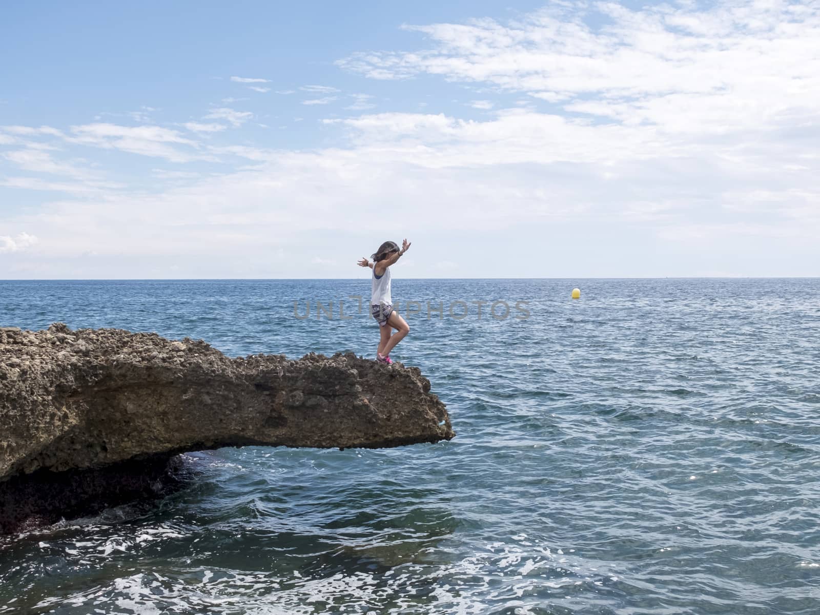 Side view of a woman standing on sea rocks