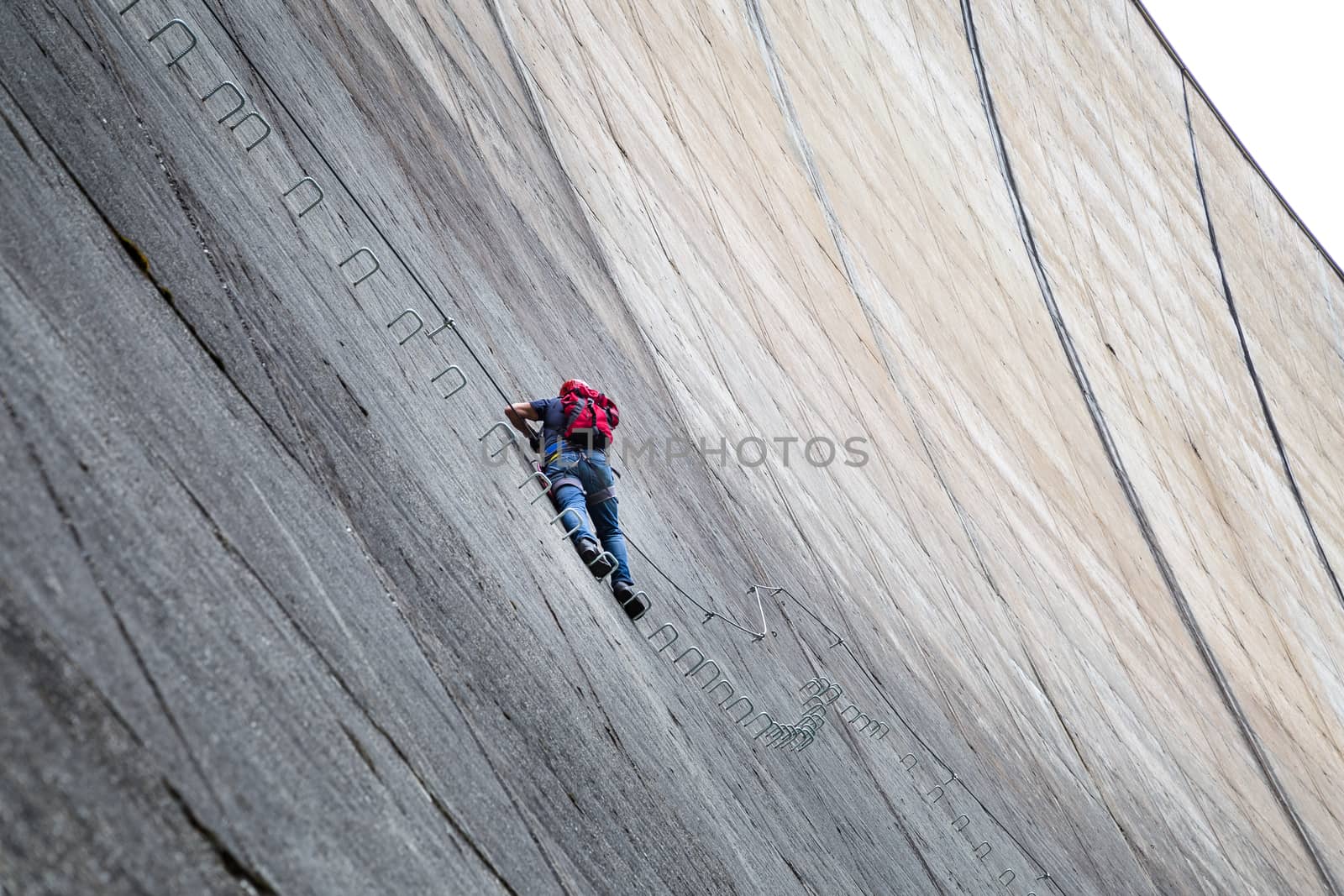 Finkenberg, Austria - June 9, 2018: An alpinist climbing the Via Ferrata on the Schlegeis Dam