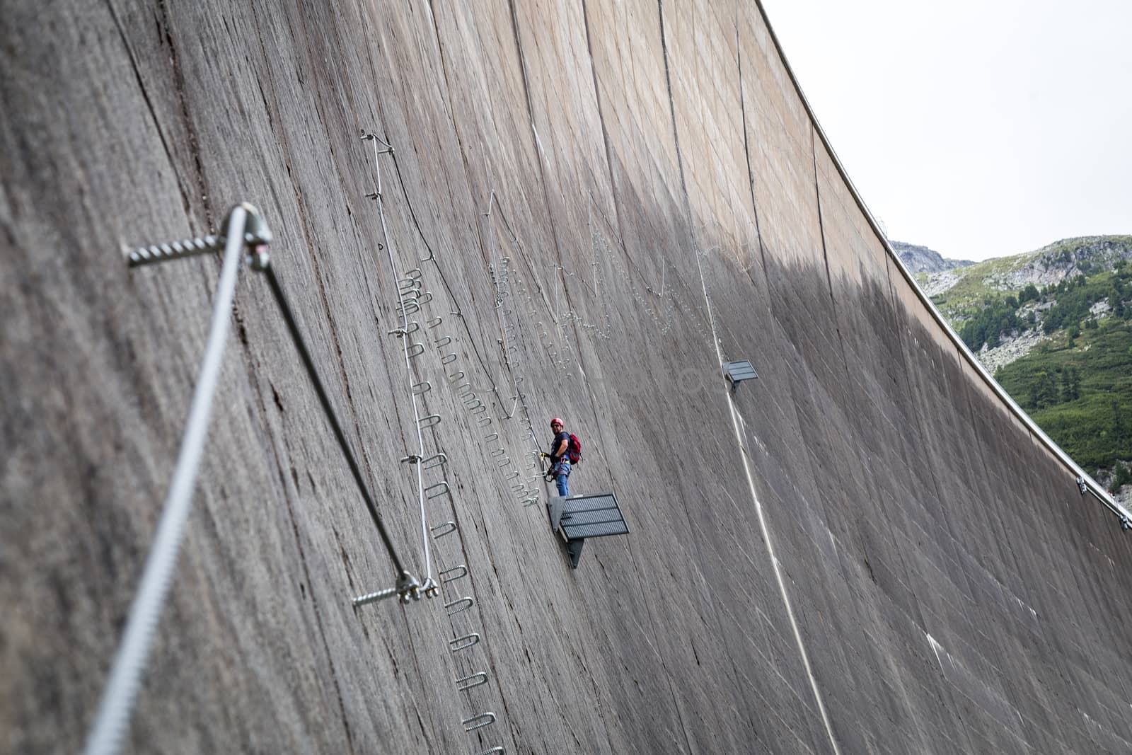 Finkenberg, Austria - June 9, 2018: An alpinist climbing the Via Ferrata on the Schlegeis Dam