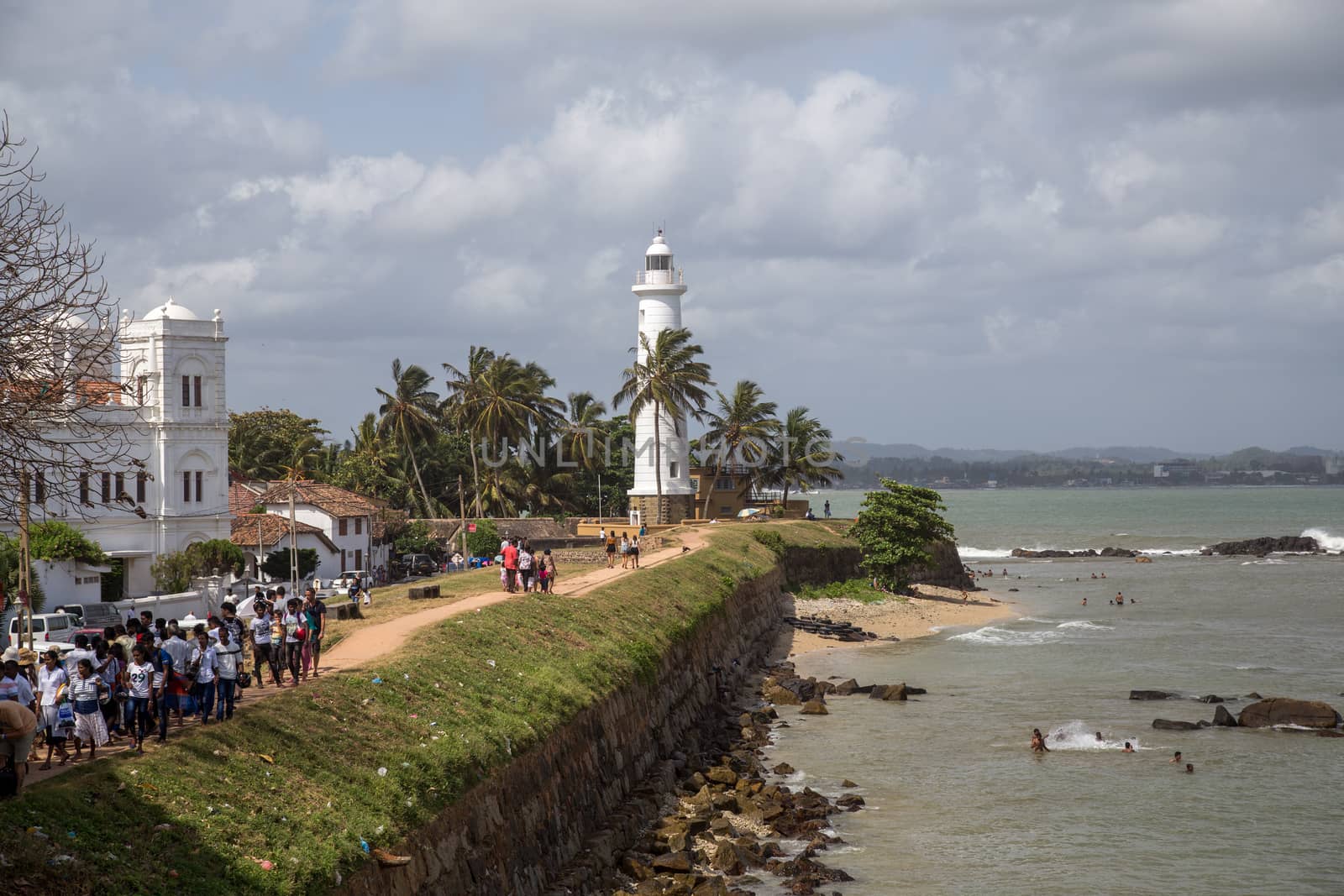 Galle Fort, Sri Lanka - July 27, 2018: The lighthouse and people walking on the fort wall