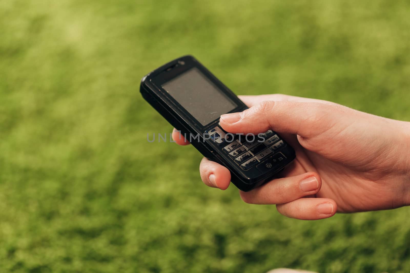 Girl Holds An Old Button Phone In Her Hand.