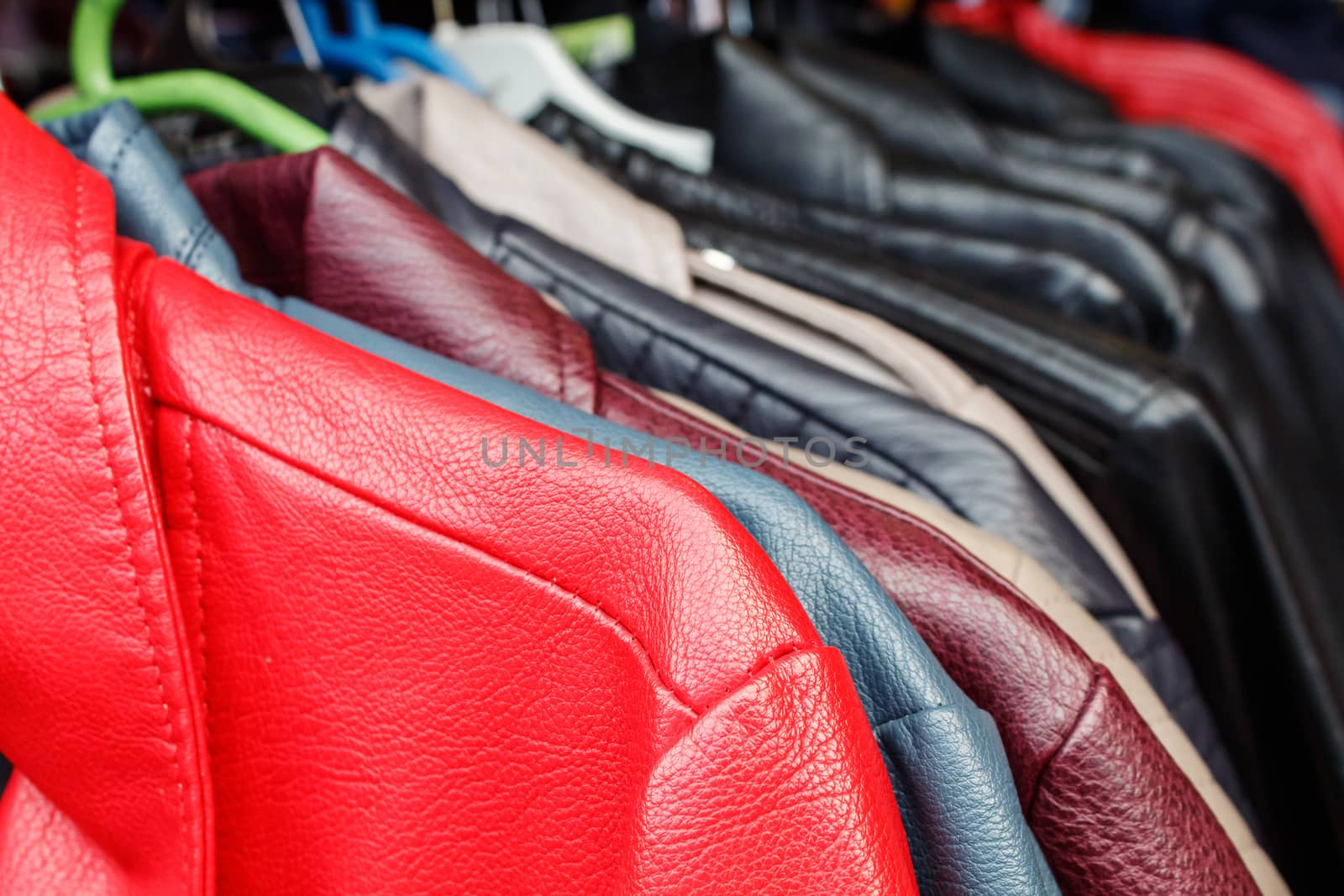 leather jackets hanging on a hanger in the city market outdoor on autumn day