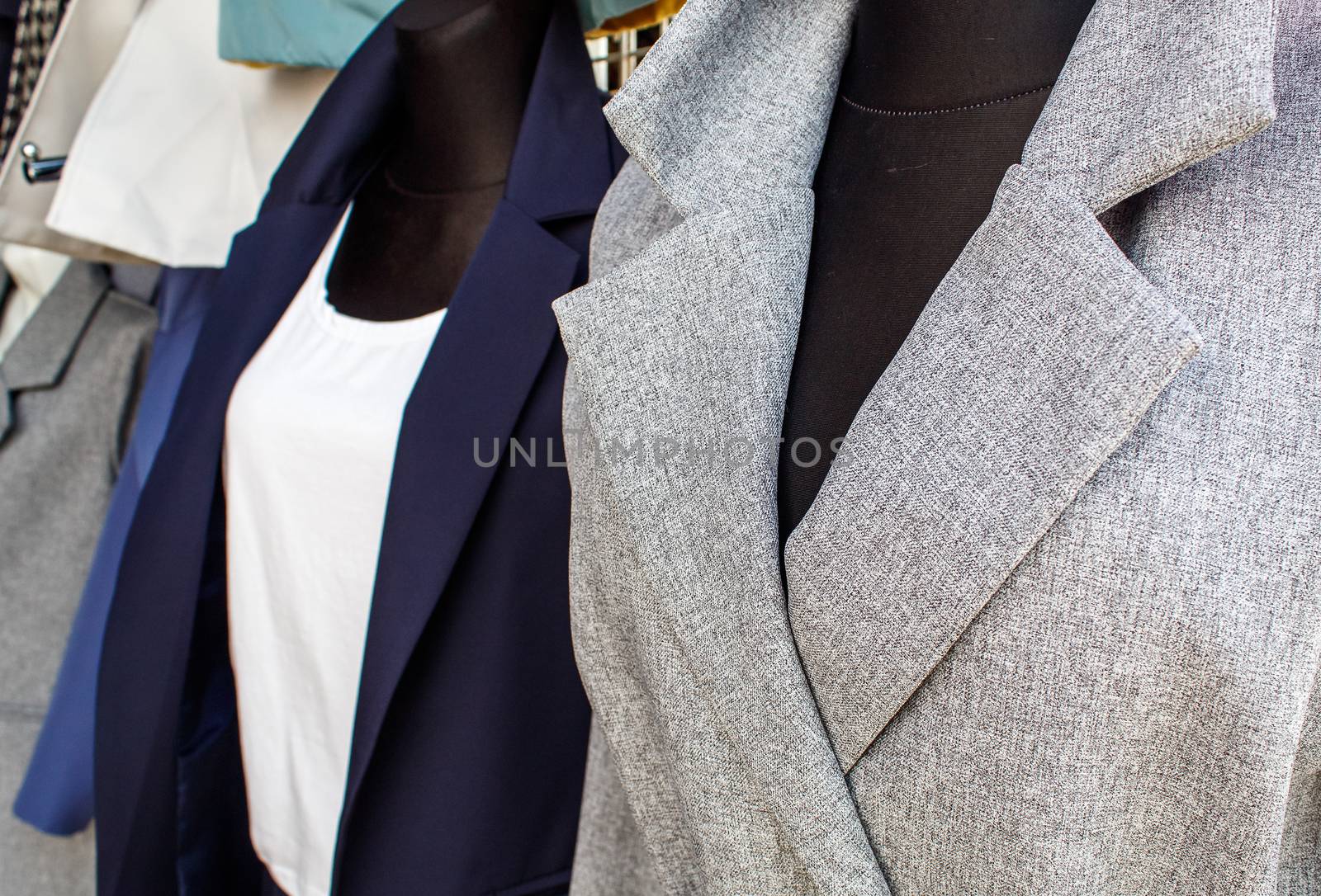 several women's coats worn on mannequins in the city market outdoor on autumn day