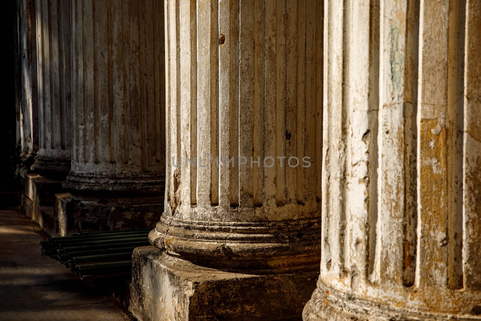 Ruined old columns with base and flute. Sunlight