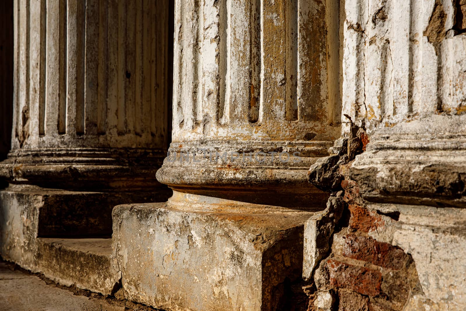 Ruined old columns with base and flute. Sunlight