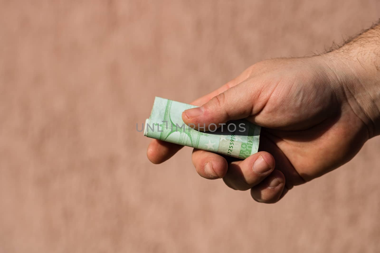 Man hands giving money like a bribe or tips. Holding EURO banknotes on a blurred background, EU currency